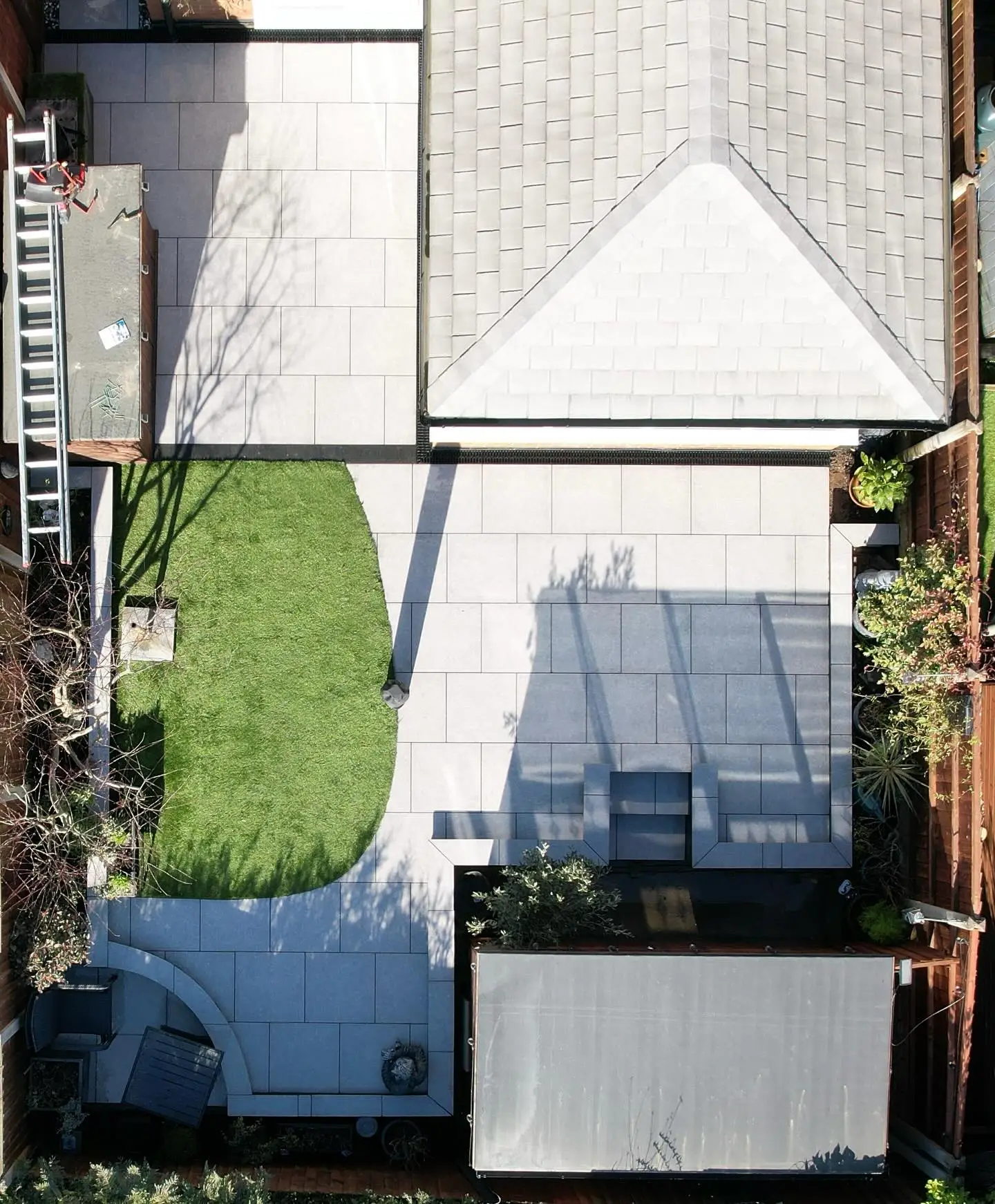 Aerial drone view of a curved porcelain garden with a soft lawn