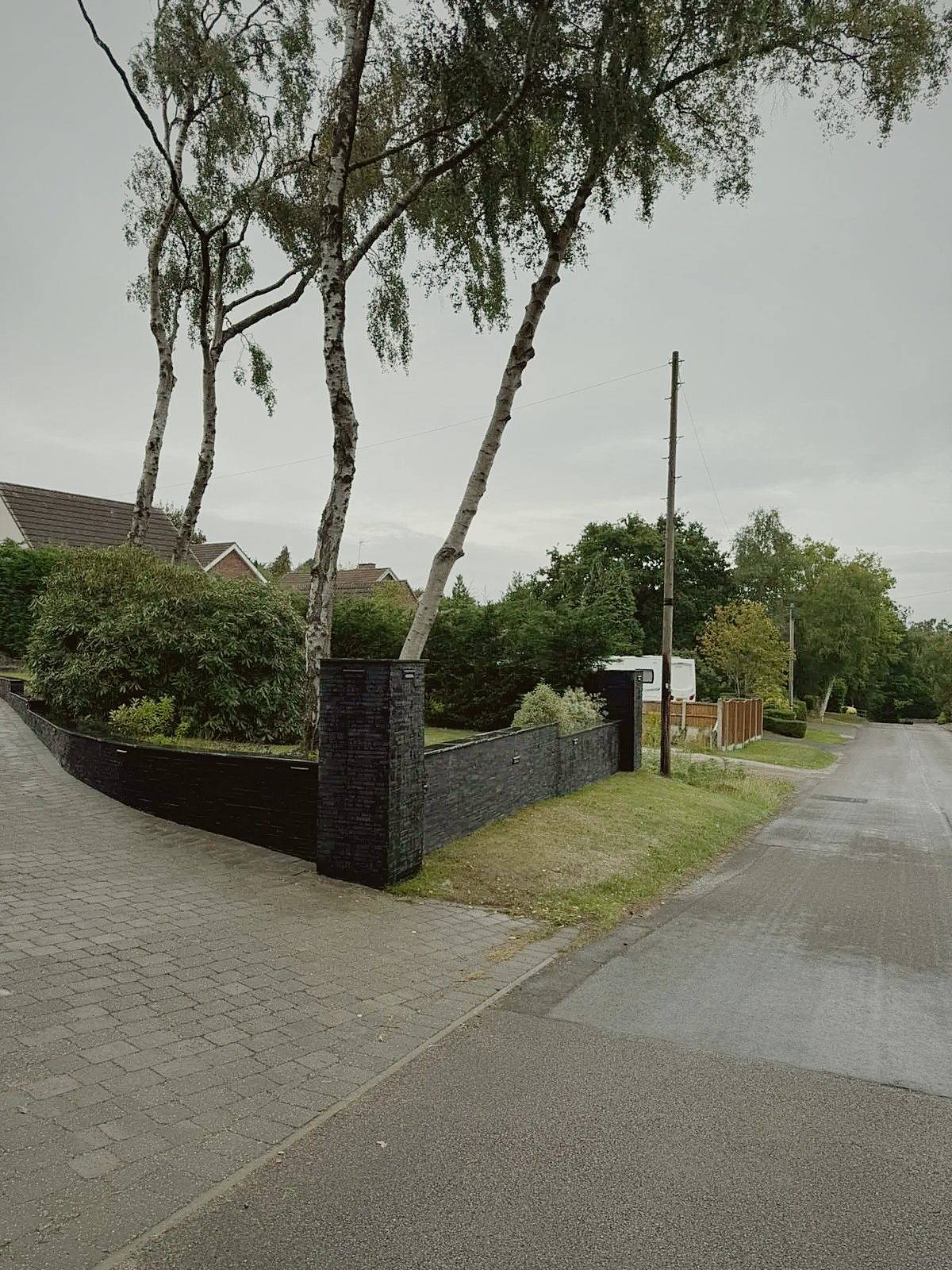 Layered slate boundary walls framing a front garden and driveway