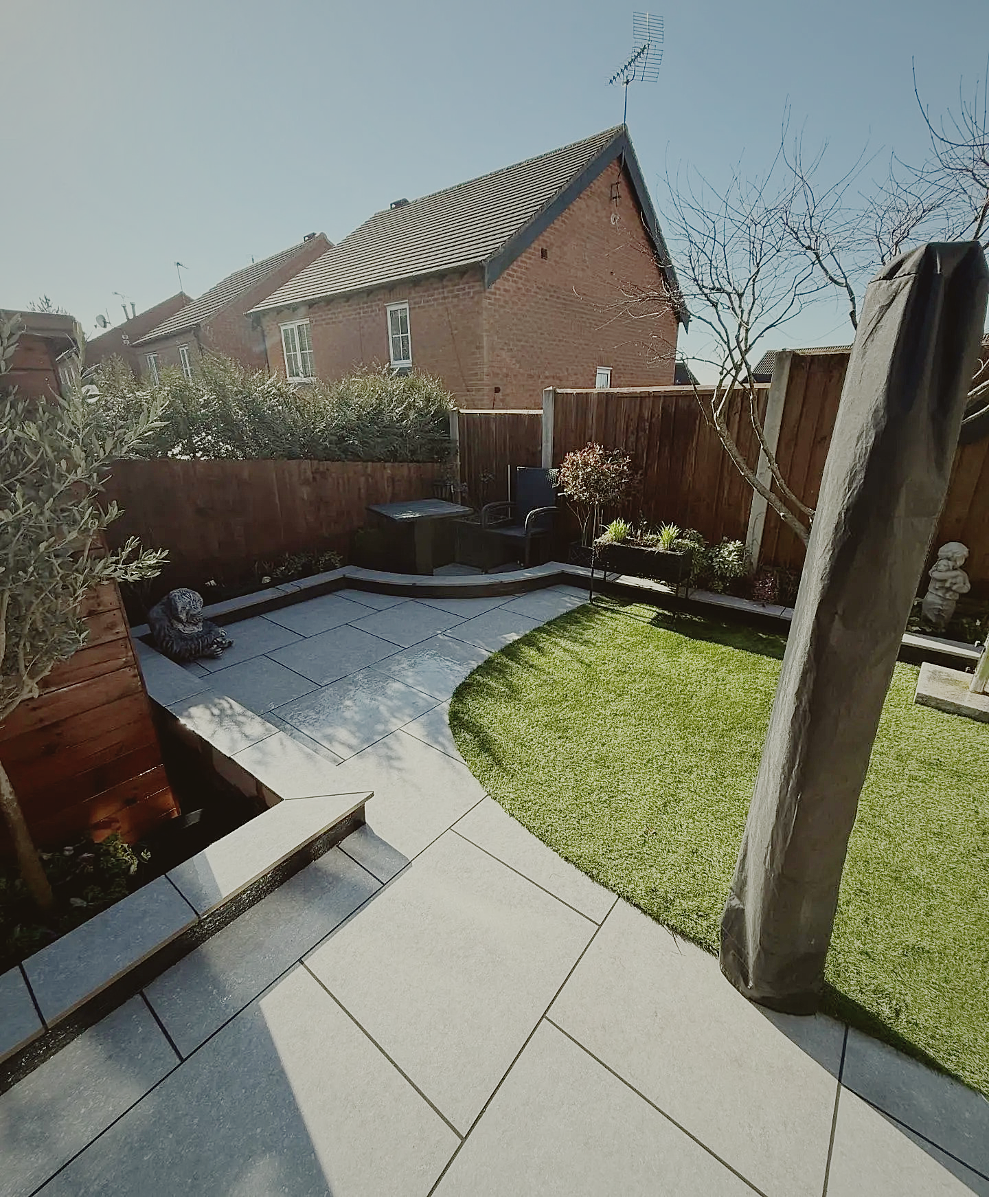 Soft morning light across a rear garden patio and lawn
